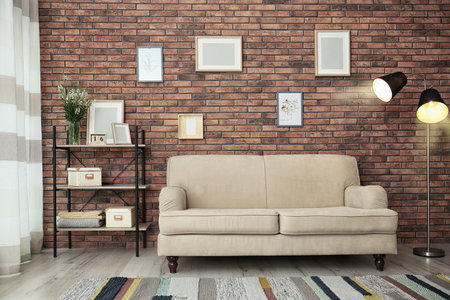 Modern living room interior with comfortable sofa near brick wallの写真素材