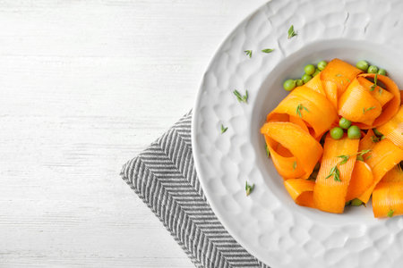 Tasty salad with fresh carrot in plate on table, top viewの写真素材