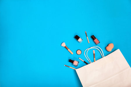 Stylish flat lay composition with shopping bag and cosmetics on color backgroundの写真素材