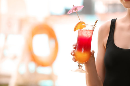Woman holding glass with delicious cocktail outdoorsの写真素材
