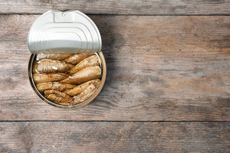 Tin can with canned fish on wooden background, top viewの写真素材