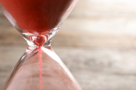 Hourglass with flowing sand on table, closeup. time managementの写真素材