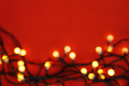 Blurred view of glowing Christmas lights on color background, top viewの写真素材