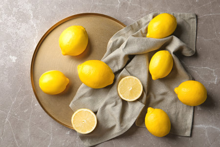 Flat lay composition with lemons, fabric and golden plate on gray backgroundの写真素材