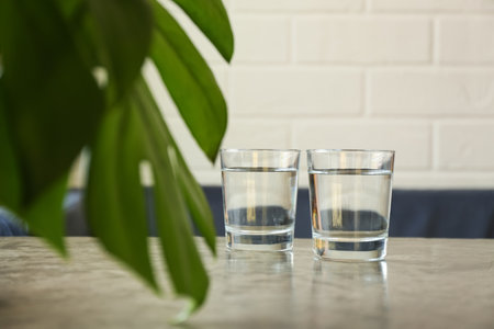 Glasses of water on gray table indoors