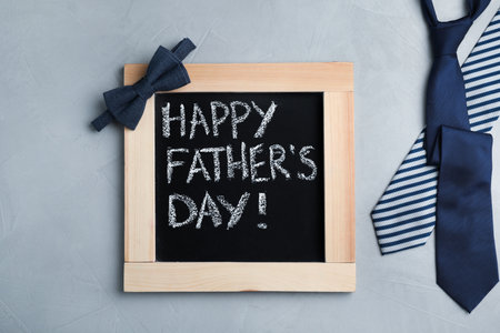 Flat lay composition with blackboard and tie on gray background. Happy Father's Dayの写真素材
