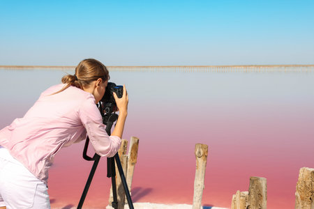 Professional photographer taking photo of pink lake on sunny dayの写真素材