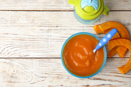Flat lay composition with bowl of healthy baby food and space for text on wooden backgroundの写真素材