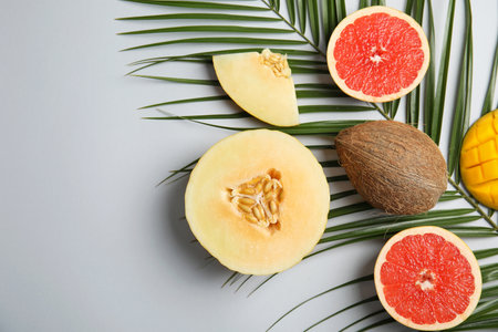 Flat lay composition with melon, other fruits and space for text on color backgroundの写真素材