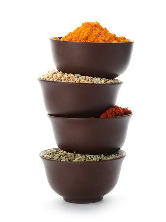 Stack of bowls with different aromatic spices on white backgroundの写真素材