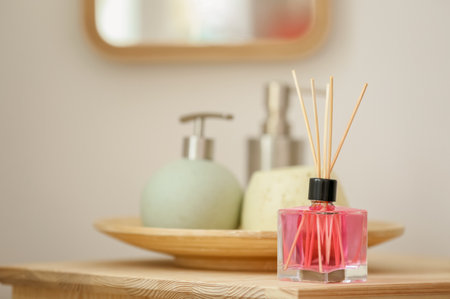 Aromatic reed air freshener and toiletries on table indoorsの写真素材
