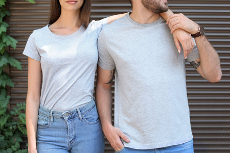 Young couple wearing gray t-shirts near wall on street.の写真素材