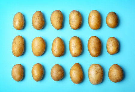 Flat lay composition with fresh ripe organic potatoes on color backgroundの写真素材