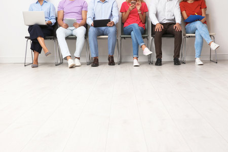 Group of young people waiting for job interview on chairs