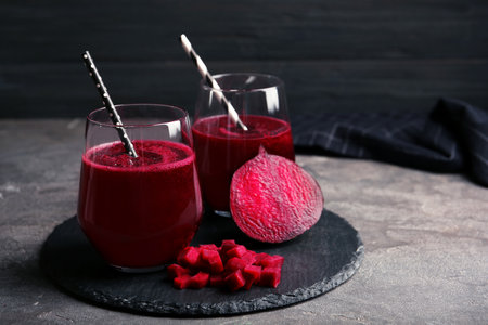 Slate plate with glasses of beet smoothies on tableの写真素材