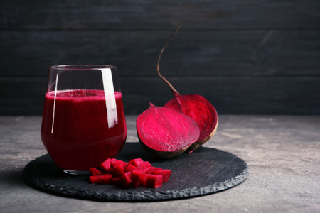 Slate plate with glass of beet smoothie on tableの写真素材