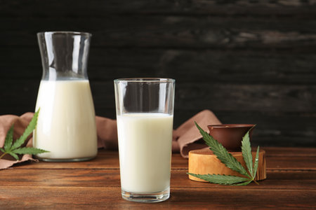 Glassware with hemp milk on wooden tableの写真素材