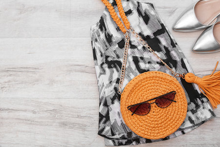 Stylish set with knitted bag and space for design on wooden background, flat layの写真素材