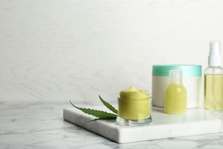 Composition with hemp lotion on marble table. Space for textの写真素材