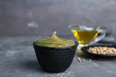 Bowl with hemp lotion on gray tableの写真素材