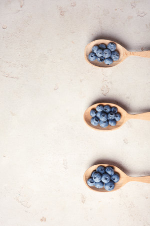 Flat lay composition with spoons and juicy blueberries on color table. Space for textの写真素材