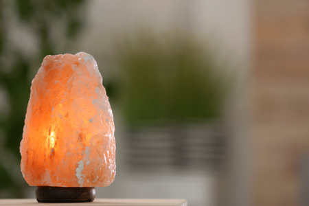 Himalayan salt lamp on table against blurred backgroundの写真素材