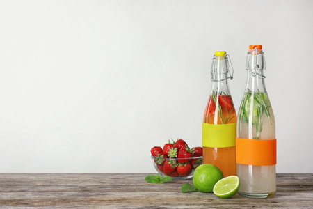 Bottles with natural lemonade on table against white backgroundの写真素材
