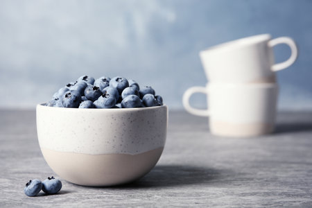 Crockery with juicy and fresh blueberries on blurred backgroundの写真素材