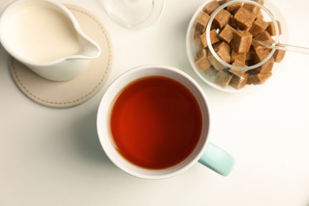 Cup of black tea and milk on table, top viewの写真素材