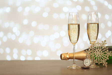 New year composition with champagne and space for text against blurred Christmas lightsの写真素材