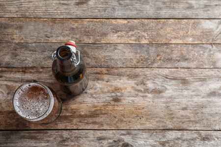 Bottle and glass with tasty cold beer on wooden backgroundの写真素材