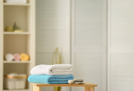 Clean towels and stones on table against blurred backgroundの写真素材