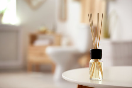 Aromatic reed air fresher on table against blurred backgroundの写真素材