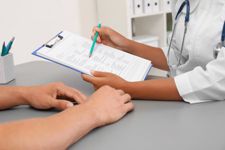 Female doctor working with patient at table in hospital, closeupの写真素材