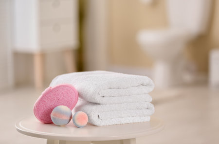 Clean towels and toiletries on table against blurred backgroundの写真素材