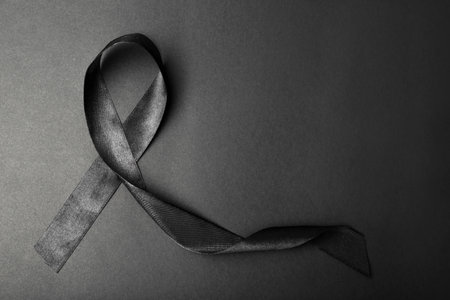 Black ribbon and space for text on dark background, top view. funeral accessoryの写真素材