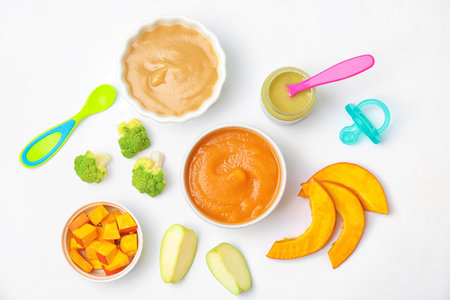 Flat lay composition with bowls of healthy baby food on white backgroundの写真素材