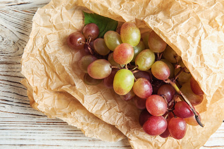 Fresh ripe juicy grapes and paper on table, top viewの写真素材