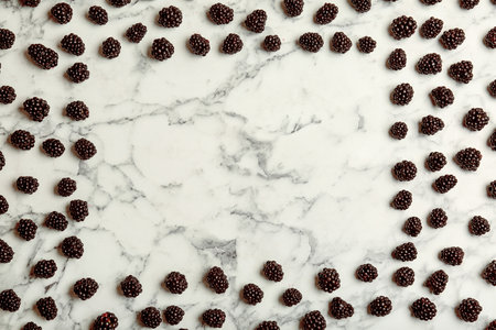Flat lay composition with fresh blackberry and space for text on marble background