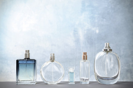 Different perfume bottles on table against color backgroundの写真素材