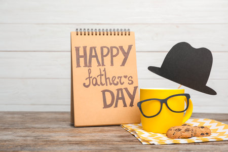 Composition with notebook, cup and glasses on wooden table. father's day celebrationの写真素材