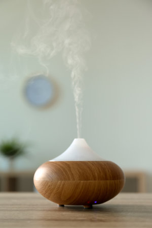 Modern aroma lamp on table in roomの写真素材