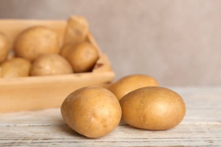Fresh ripe organic potatoes on wooden tableの写真素材