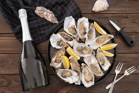 Fresh oysters with cut juicy lemon served on table, flat layの写真素材