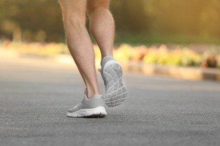 Young man running in park, focus on legsの写真素材