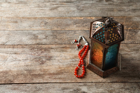 Muslim lamp and misbaha on wooden background. Fanous as Ramadan symbolの写真素材