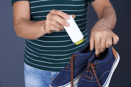 Man putting powder shoe fresher in footwear on color background, closeupの写真素材
