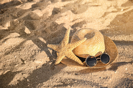 Straw hat, starfish and sunglasses on beach sand. summer holidaysの写真素材