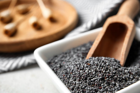 Bowl with scoop and poppy seeds on table, closeupの写真素材