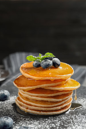 Tasty pancakes with berries and honey on slate plateの写真素材
